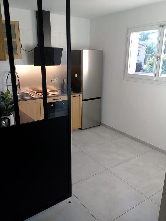 a kitchen with a stainless steel refrigerator in a room at Le Baou fully renovated 2025 in Sanary-sur-Mer