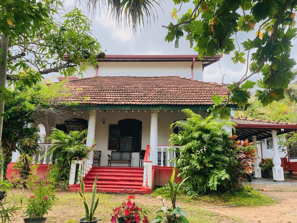a small house with a red and white at Veron Marina Villa in Unawatuna