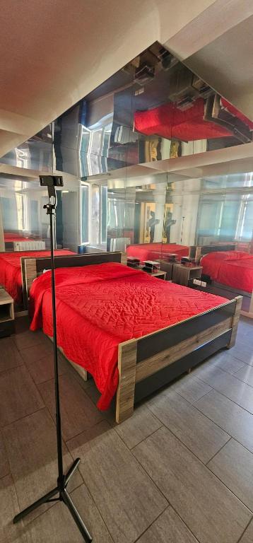 une chambre avec un lit avec une couette rouge dans l'établissement T2 Chambre Miroir jardin et parking privé Marseille, à Marseille