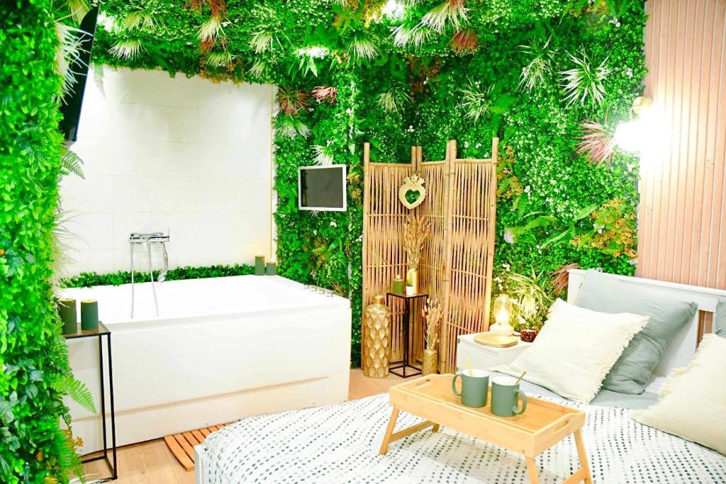 a bathroom with a green wall with a bath tub at La Boétie, Cocon Central, Double Balneo Bathtub in Bordeaux