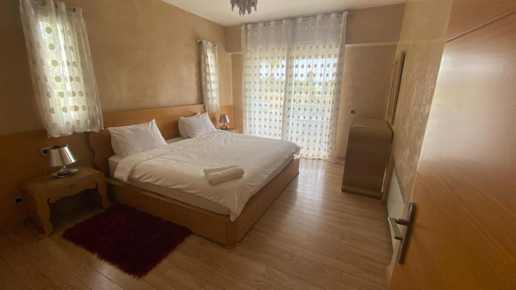 a bedroom with a bed with white sheets and white pillows at spacieux villa avec terasse centre harhoura in Temara