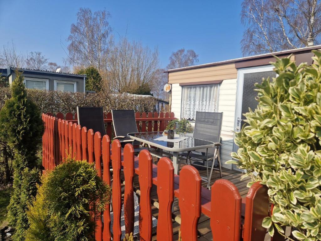 a fence with a table and chairs in a yard at Bungalow am Hafen in Gager