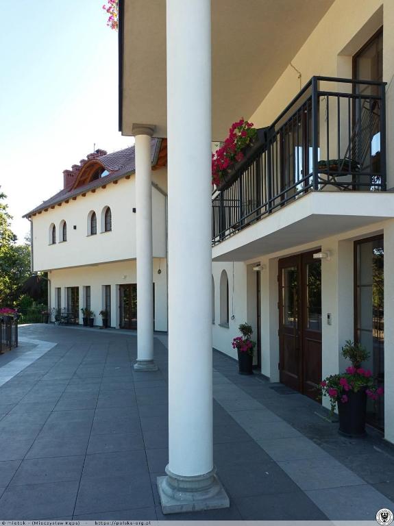 a building with columns and balconies on a street at Villa Parkova Strzelin in Strzelin