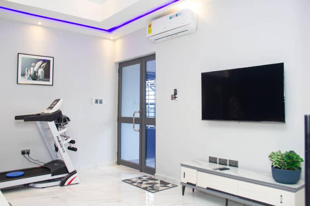a living room with a flat screen tv on a wall at Steanka Luxury Homes in Kwedonu