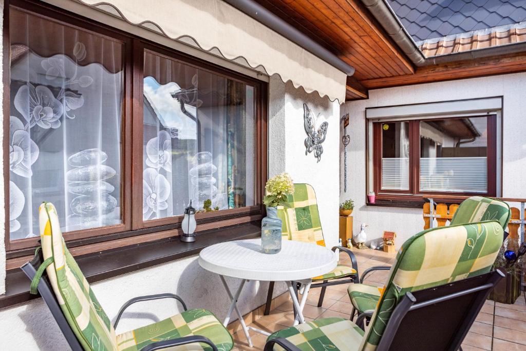 a balcony with a table and chairs and a window at Ferienwohnung Energie und Balance in Lichtenau