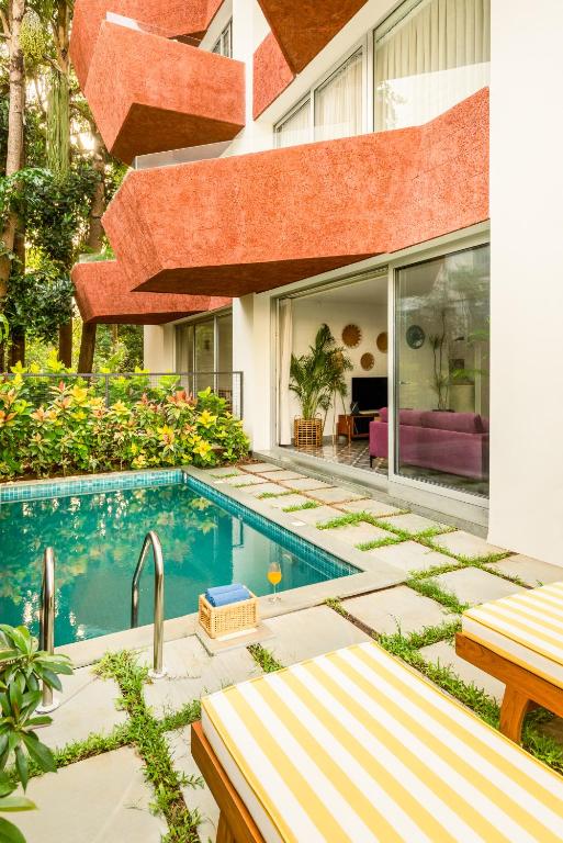 a swimming pool in the backyard of a house at El Volar by The Blue Kite - 2BHK, 5 Mins to Casino & 10 Mins to Candolim Beach with Big common Pool, Fully Equipped Kitchen, 24x7 Security, WiFi in Nerul