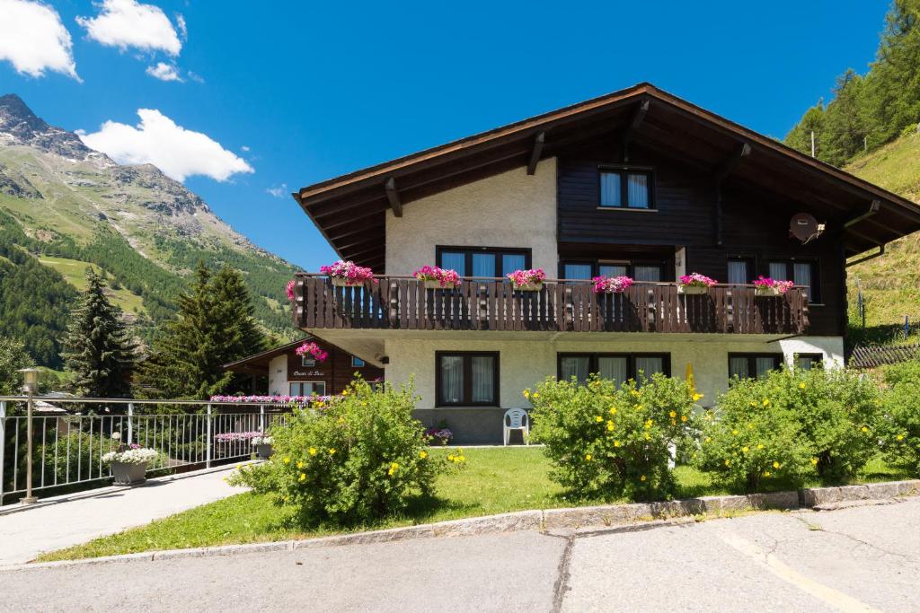 a house with a balcony with flowers on it at Apartments Orphelja in Saas-Grund