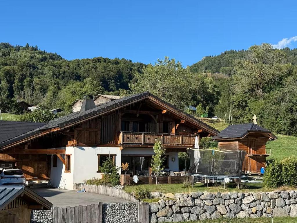 ein Haus in den Bergen mit einer Steinmauer in der Unterkunft Beautiful chalet with swimming pool & great garden in Samoëns