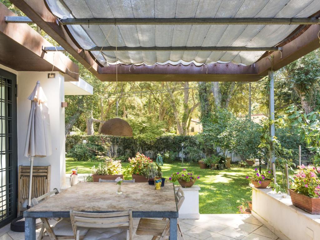 a patio with a wooden pergola with a table and chairs at Holiday Home La casina nel bosco by Interhome in SantʼAlfonso