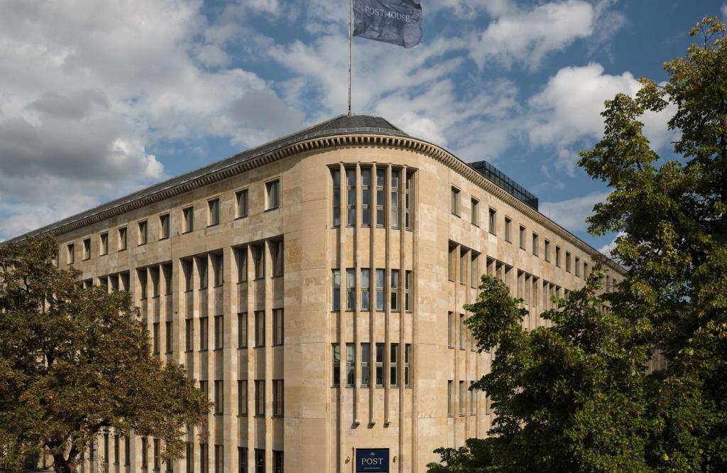 a building with a flag on the top of it at The Posthouse Berlin Potsdamer Platz- Leonardo Limited Edition in Berlin