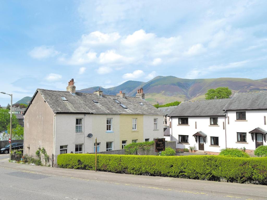 a row of white houses with mountains in the background at 14 Greta Villas in Keswick