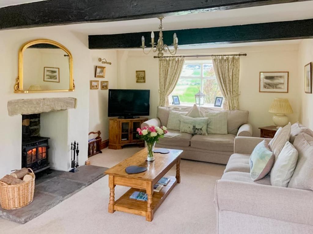 a living room with a couch and a fireplace at Royds Hall Cottage in Keighley