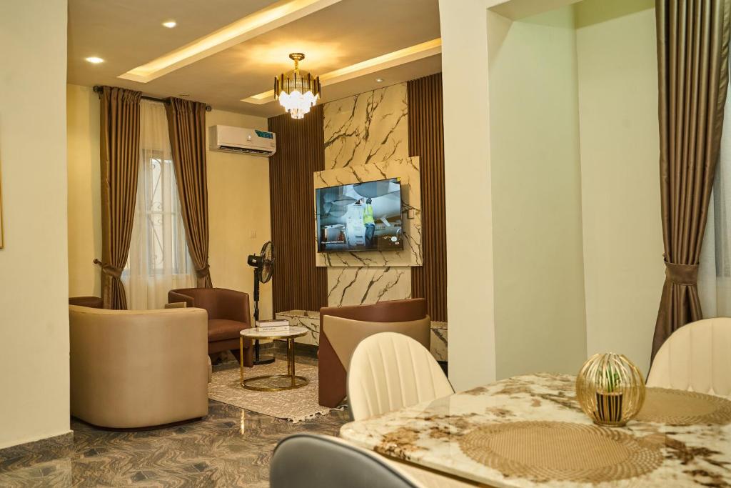 a living room with a table and chairs and a television at Shabi's Court in Lagos