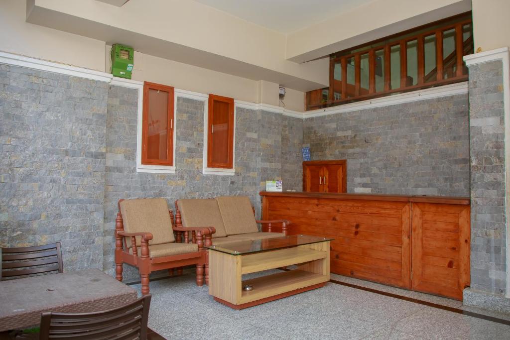 a room with two chairs and a desk and a table at Roamers Apartment in Pokhara
