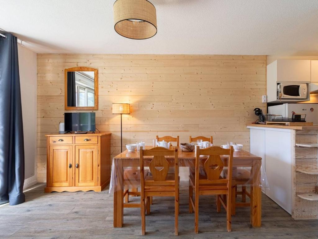 a dining room with a wooden table and chairs at Charmant Appartement 6 Pers, Pieds des Pistes avec Navette, Parking Gratuit - FR-1-695-35 in Germ