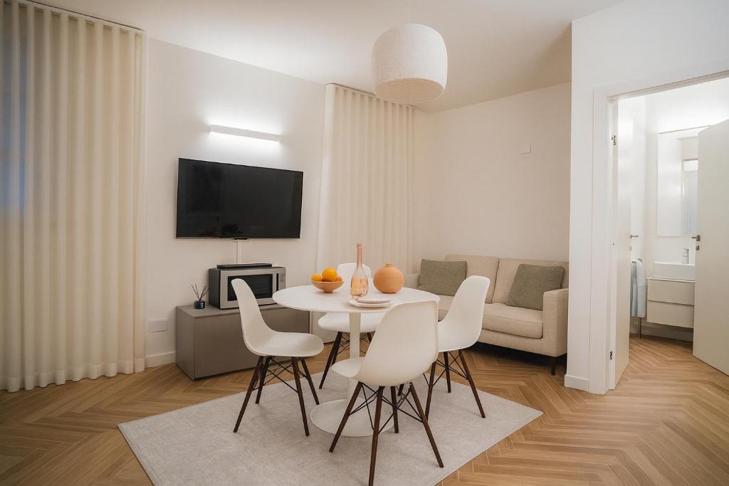 イゼーオにあるISEO LAKE - Free Wi-Fi and Private Parking Includedの白いリビングルーム(テーブル、椅子付)