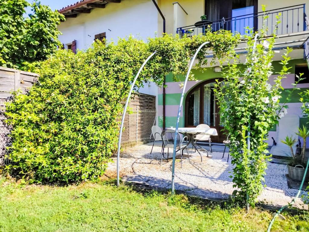 a garden with an arch and a table and chairs at Apartment La Terra by Interhome in La Morra