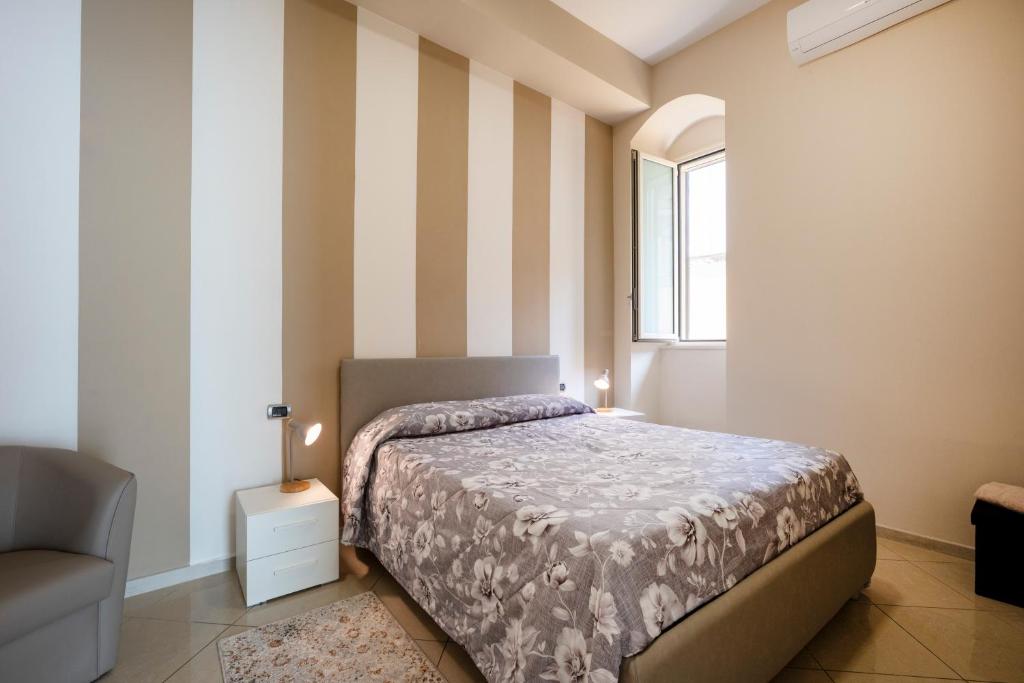a bedroom with a bed and a chair and a window at Martini Matera luxury living in Matera