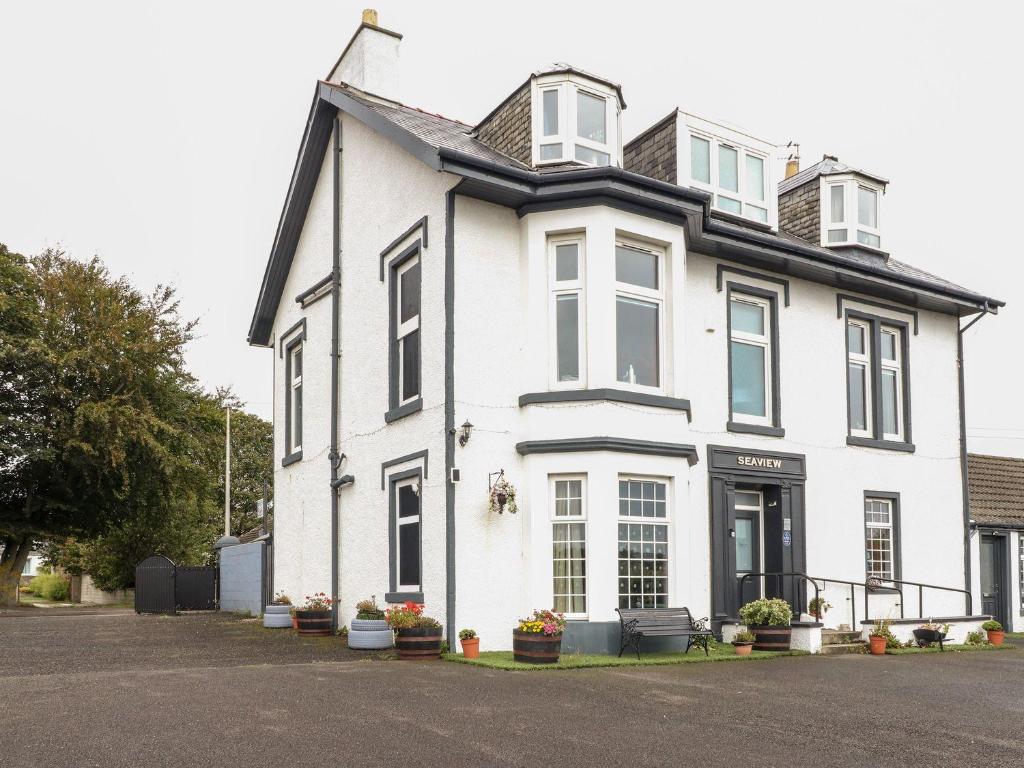 a white house with a black roof at Seaview Wellness Retreat in Carnoustie