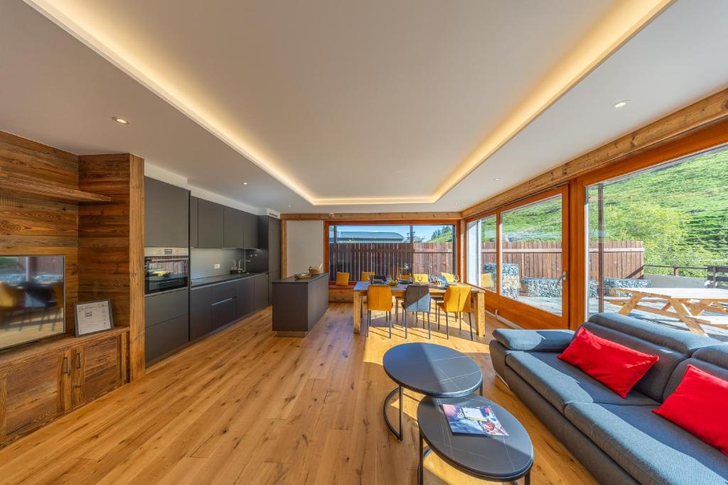 a living room with a blue couch and a kitchen at Le Chamois l Ski-out l Standing in Siviez