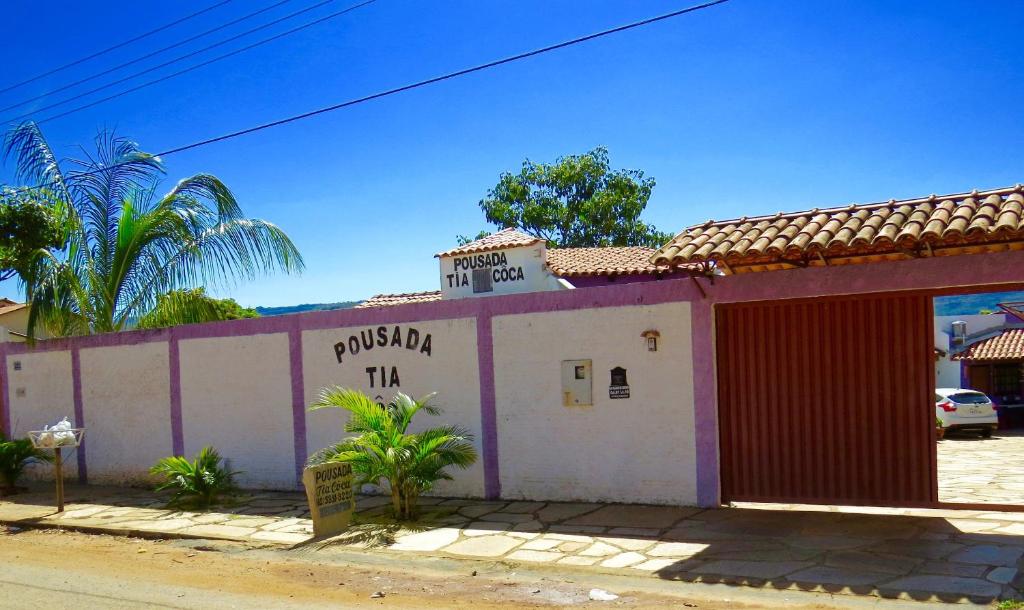 un edificio con una puerta roja y un cartel en él en Pousada Tia Côca, en Pirenópolis