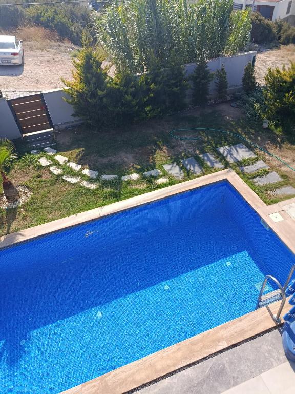 a large blue swimming pool in a yard at Havuzlu lüks villa havuzu ısıtmalı in Çeşme