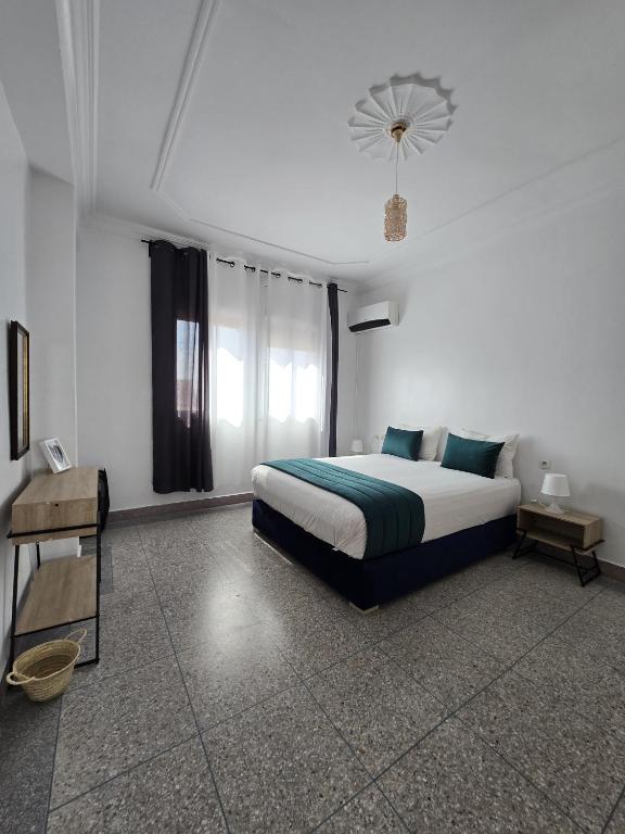 a bedroom with a large bed and a window at KARAZ Homestay Grand appartement avec rooftop in Monte ʼArrouit
