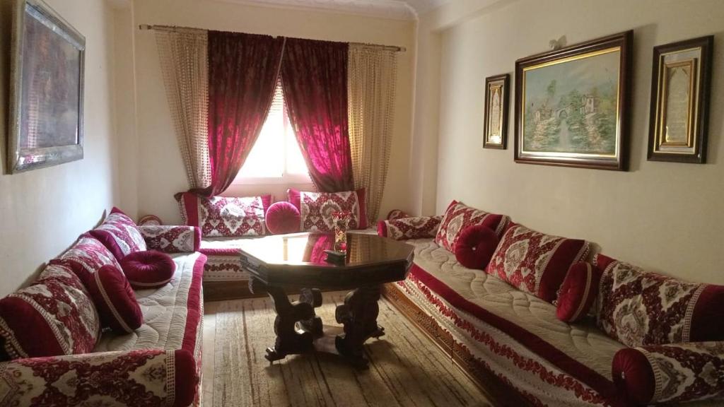 una sala de estar con un sofá y una mesa en Appartement Familial pres la nouvelle gare routière & Grand Stade de Tanger, en Tánger