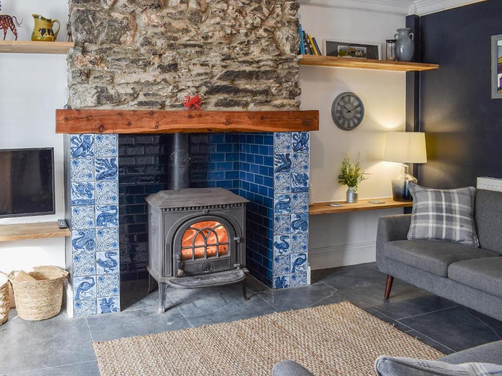 a living room with a blue tile fireplace at White Horses - Uk42776 in Newborough