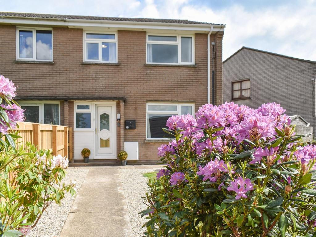a house with pink flowers in front of it at Greenbank Cottage in Great Torrington