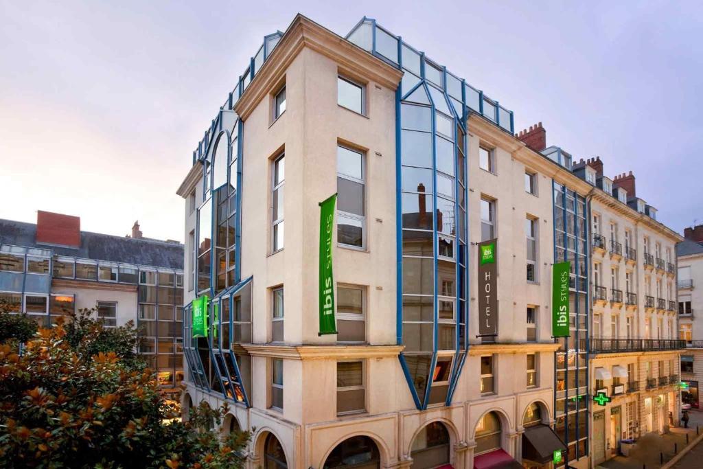 a building with green signs on the side of it at ibis Styles Nantes Centre Place Royale in Nantes