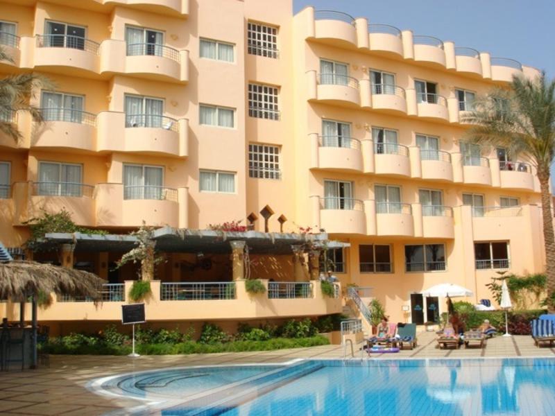 un hotel con piscina frente a un edificio en Sea Garden Hotel, en Hurghada