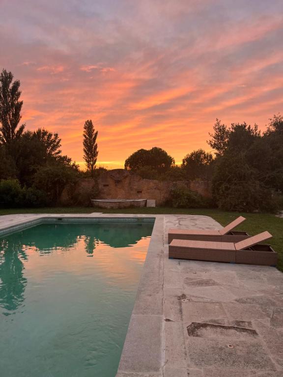 einen Pool mit 2 Liegestühlen und Sonnenuntergang in der Unterkunft Maison 2 ch en campagne 5 mn du centre en voiture avec possibilité piscine familiale in Salon-de-Provence