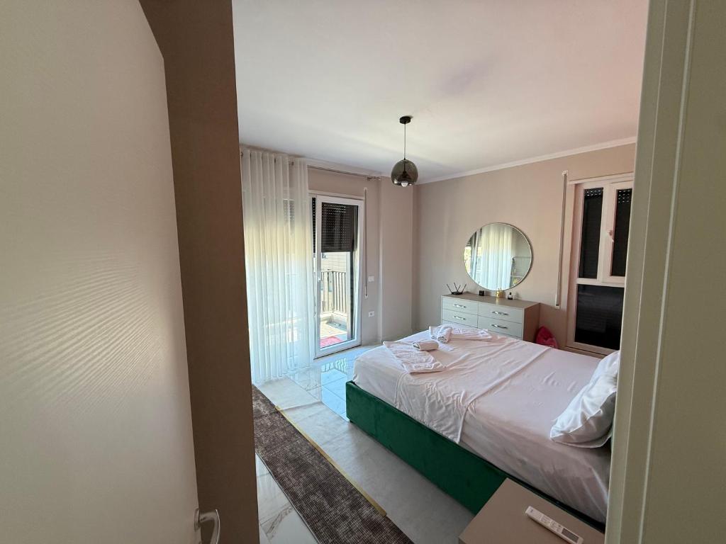 a bedroom with a large bed and a mirror at Mikels Apartment in Tirana