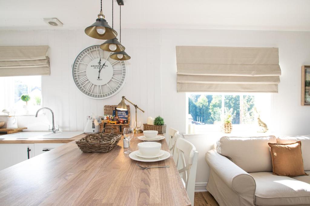 インバネスにあるLillymont Apartment - Inverness City Centreのキッチン、リビングルーム(テーブル、時計付)