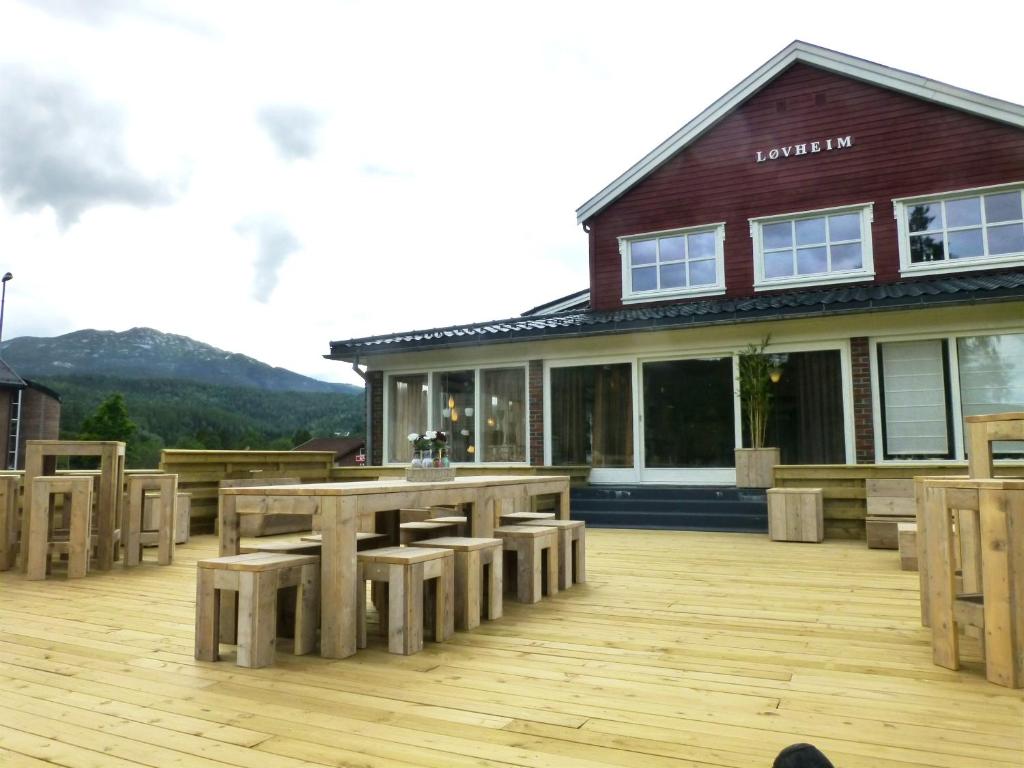 a patio with a table and benches and a building at Løvheim Gjestehus in Sauland