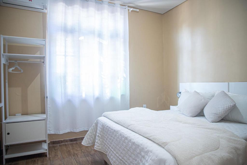 ein Schlafzimmer mit einem weißen Bett und einem Fenster in der Unterkunft Casa térrea geminada aconchegante AV3402 in Higienópolis