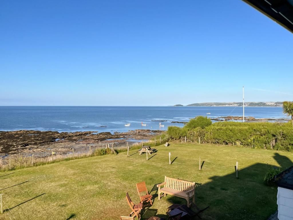 a park with a bench and the ocean in the background at Coastguard Cottage in Downderry
