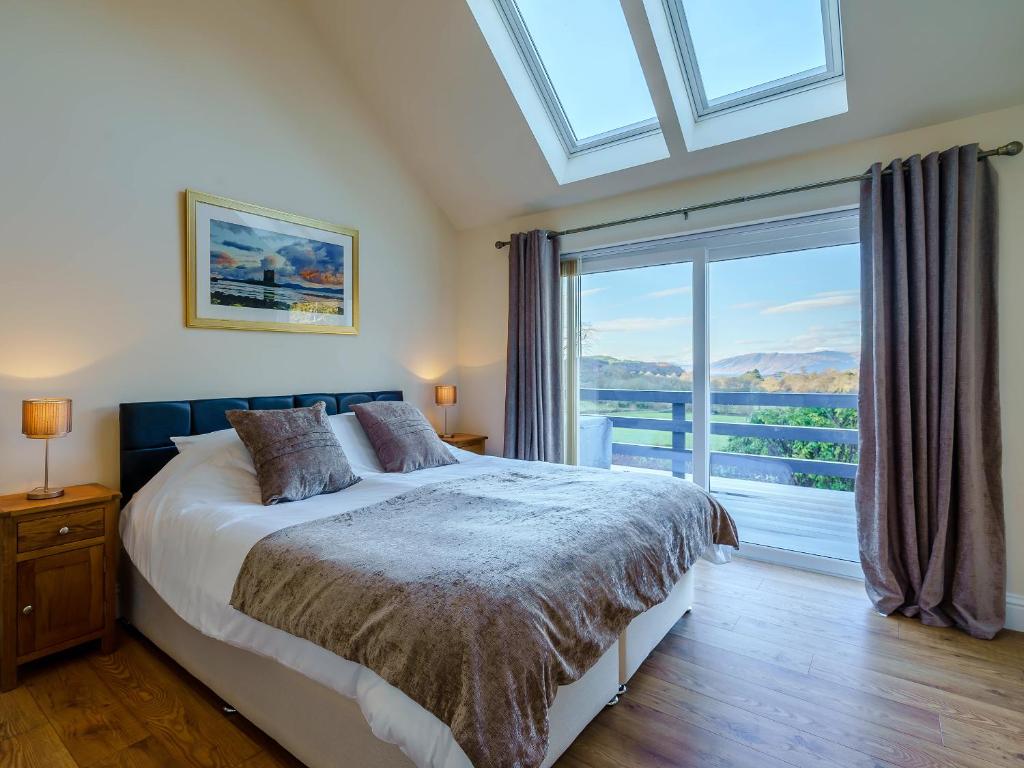 una camera da letto con un letto e una grande finestra di Invernahyle Cottage ad Acharra