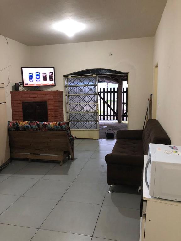 a living room with a couch and a fireplace at Aconchego do Mar in Ubatuba