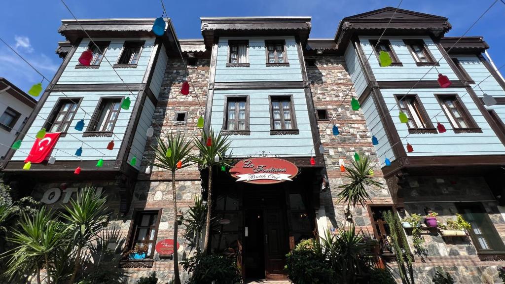 dos edificios altos con palmeras delante de ellos en La Fontaine Otel, en Mudanya