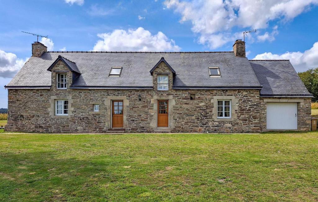 Saint-GravéにあるBelle Maison Bretonne En Pierrの大庭付きの大きな石造りの家