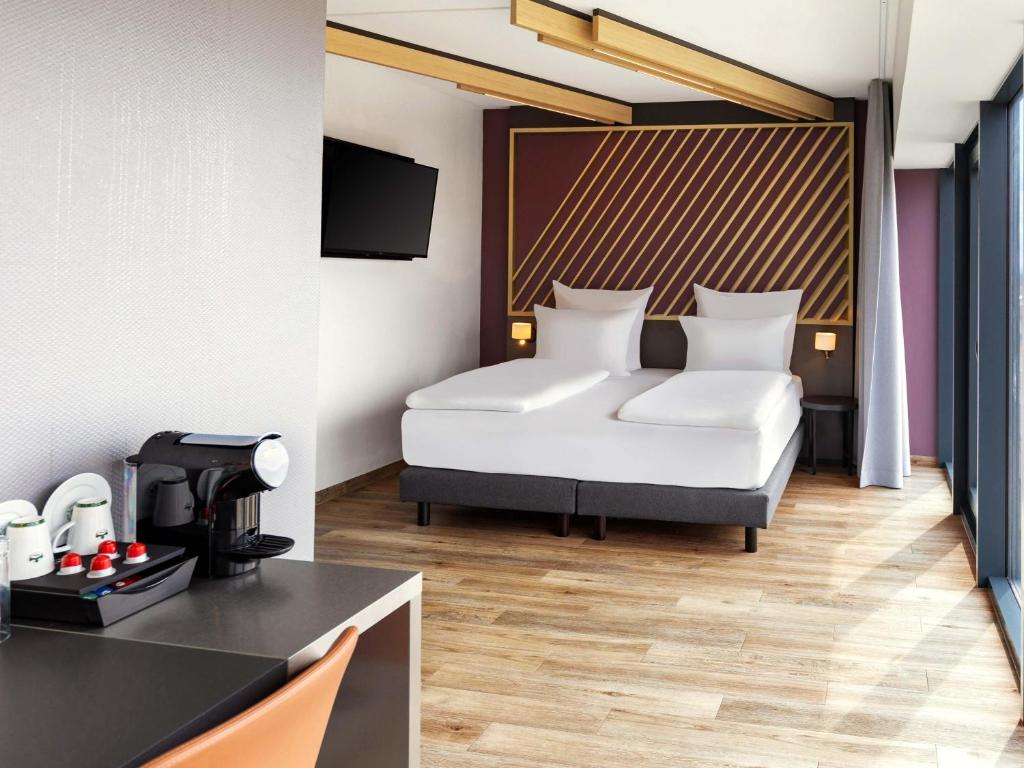 a hotel room with a bed and a table at B&amp;B HOTEL Fulda-Hbf in Fulda