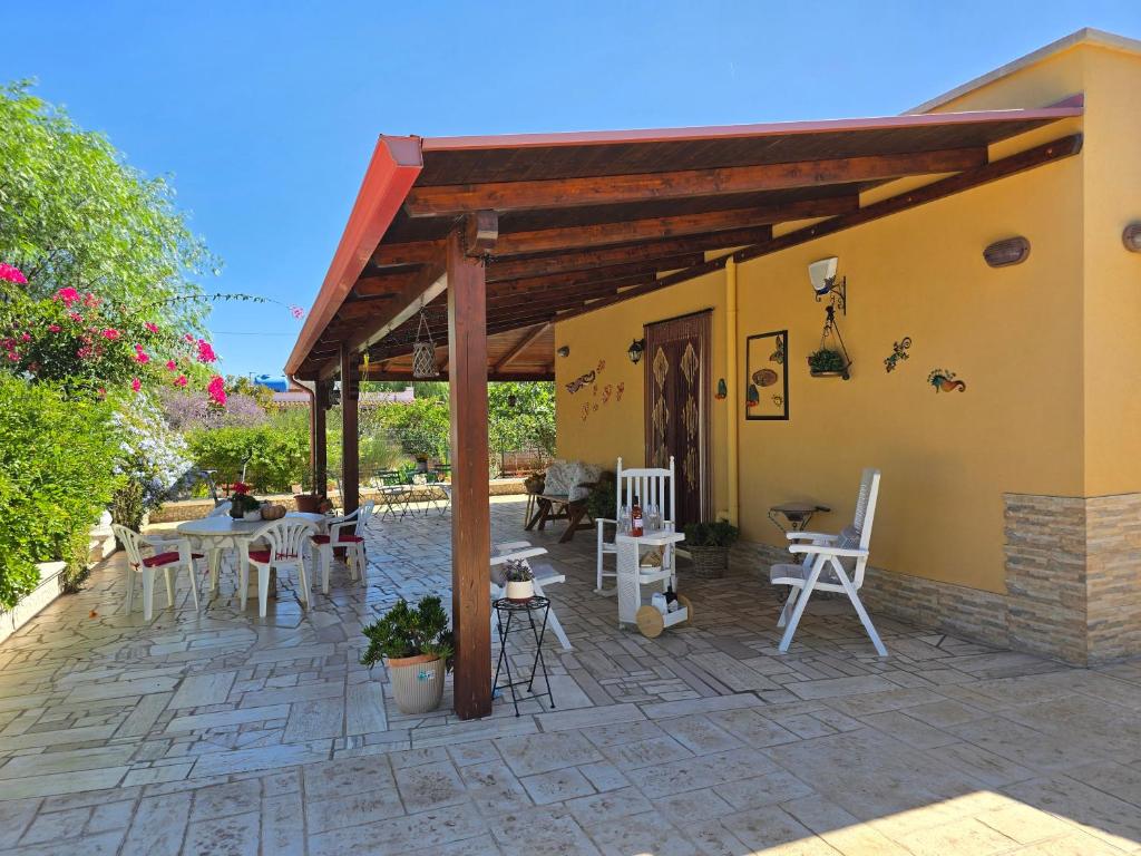 un patio avec des tables et des chaises à l'extérieur d'un bâtiment dans l'établissement A casa di Isor, à San Vito dei Normanni