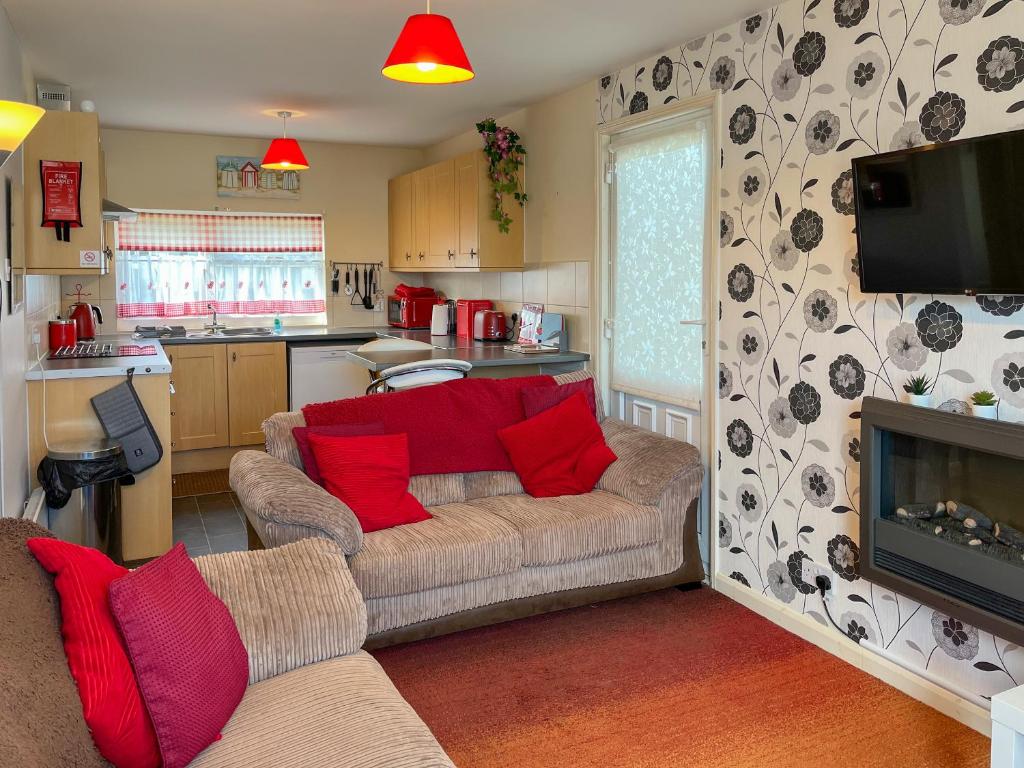 a living room with a couch with red pillows at Rosie's Cottage in Bridlington