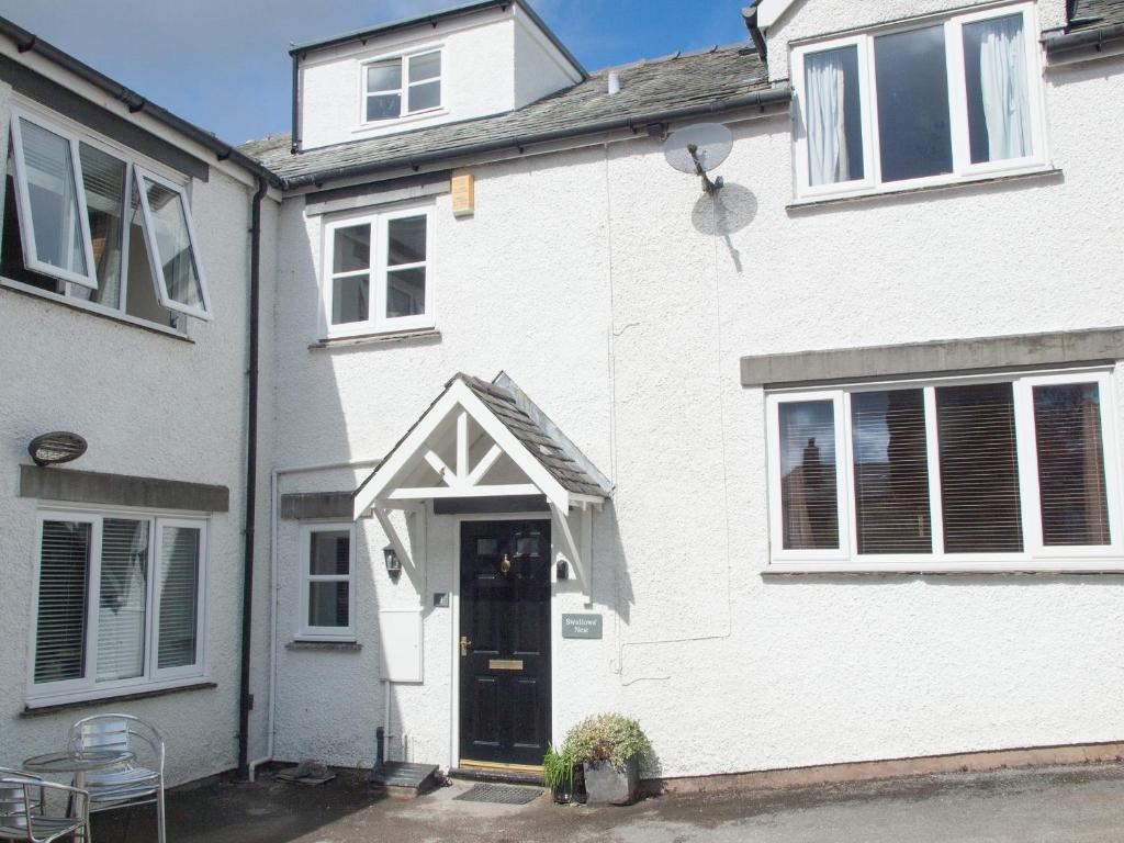 Casa blanca con puerta y ventana en Swallows Nest, en Windermere