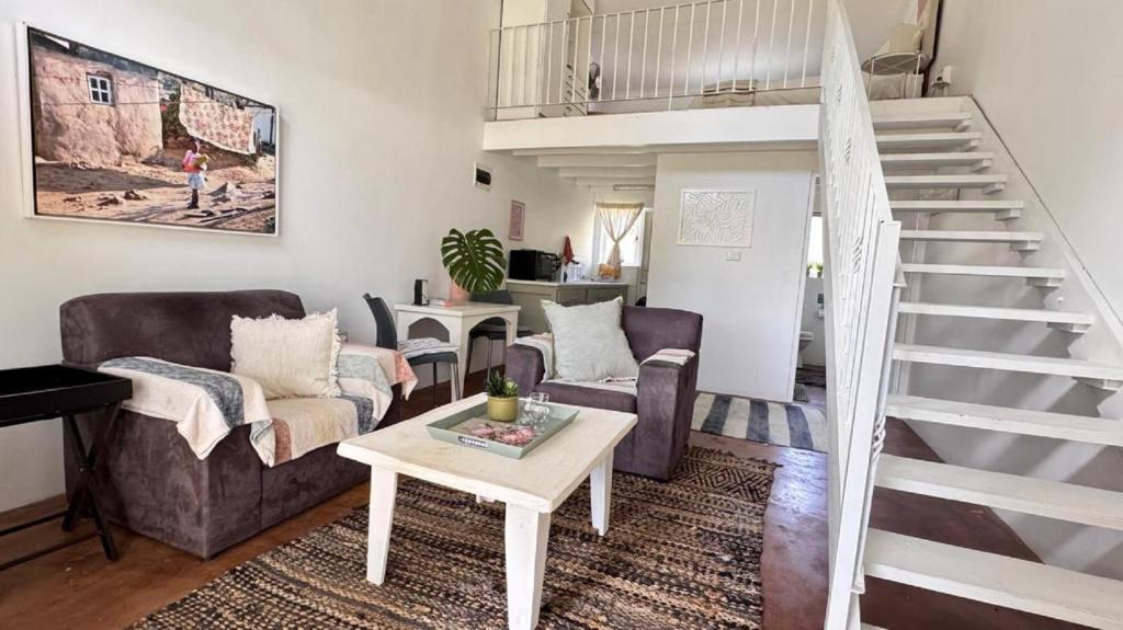 a living room with a couch and a staircase at Anamcara Villa 2, Natal Midlands Balgowan in Balgowan