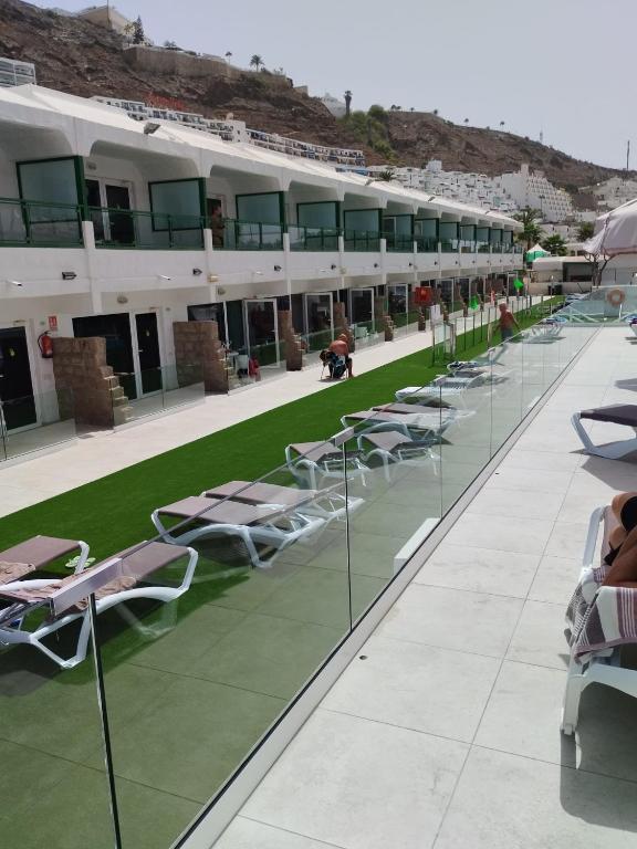 a row of lounge chairs and tables on a building at Apartamentos Florida Gran Canaria Adults Only in Puerto Rico de Gran Canaria