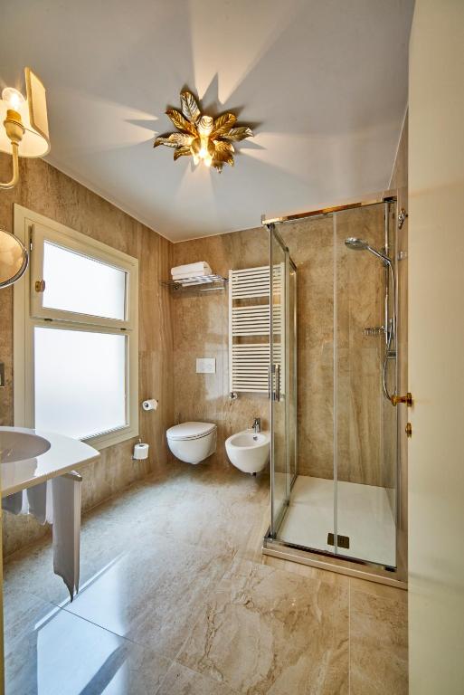 a bathroom with a shower and a tub and a sink at Hotel Gardena in Venice