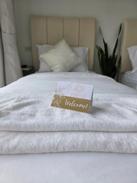 a sign on top of a white bed at Treat Boutique HuaHin 94 in Hua Hin